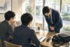 導入事例取材の前に、担当者が深く頭を下げて謝罪する場面