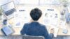 情報設計と感情設計を机上で見比べるディレクターの後ろ姿